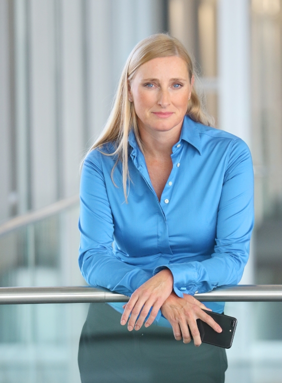 twin Werbeagentur | Business- und Imagefotografie | Geschäftsfrau mit blauer Bluse und Handy in der Hand